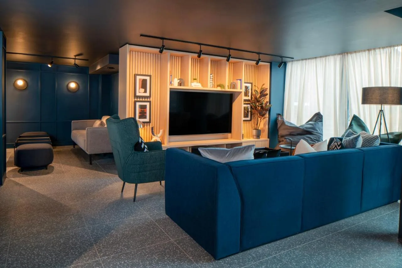 a living room with a blue couch and a tv at Aparthotel Birmingham in Birmingham