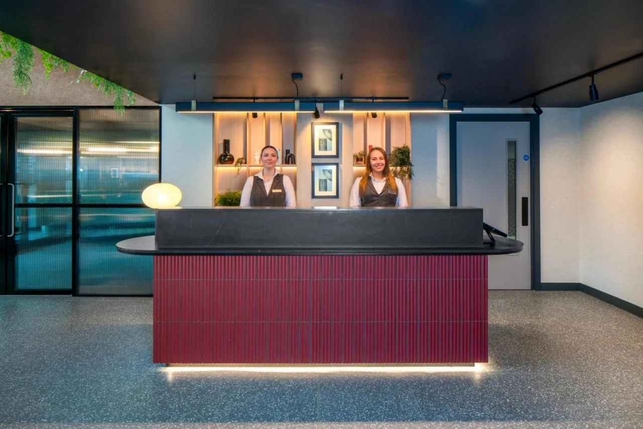 two people standing at a bar in a room at Aparthotel Birmingham in Birmingham