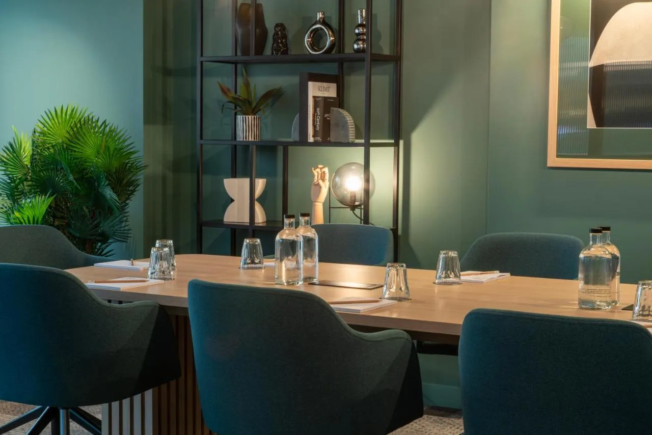 a conference room with a wooden table and blue chairs at Aparthotel Birmingham in Birmingham